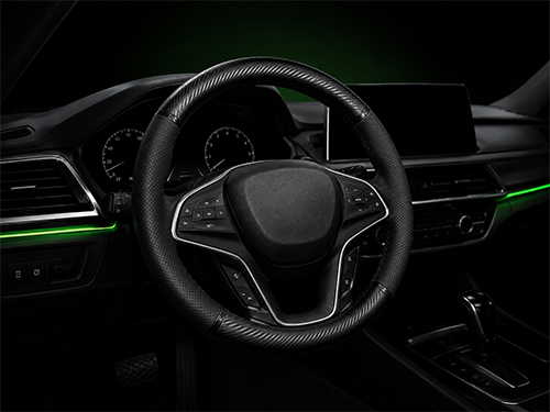 Black leather steering wheel cover with green stitching on a 38 cm wheel